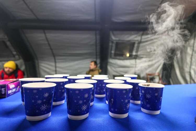 Gorąca herbata w ogrzewanym namiocie pomocy dla mieszkańców Warszawy