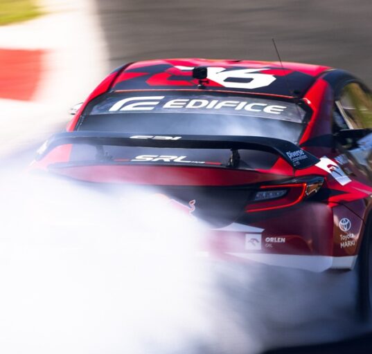 Jakub Przygoński podczas rundy Drift Masters w Madrycie wykonuje efektowny przejazd driftingowy czerwonym samochodem ORLEN OIL w kłębach dymu